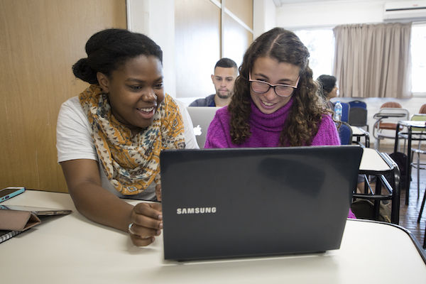 Two students using one laptop